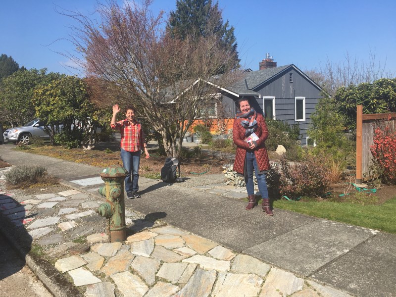 Two women stand on a suburban street