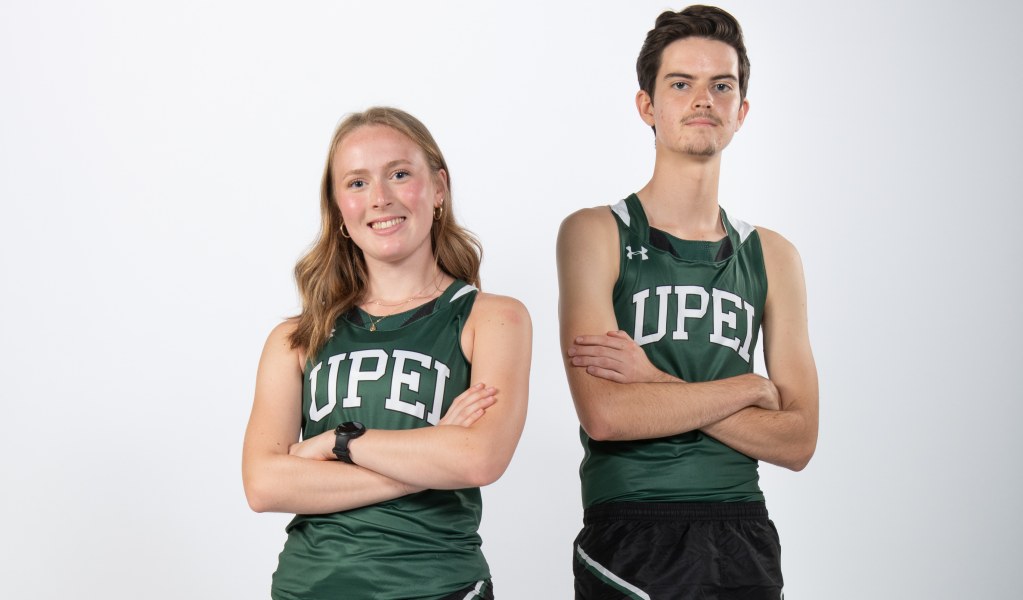 A female and male athlete post for the camera with crossed arms, looking tough