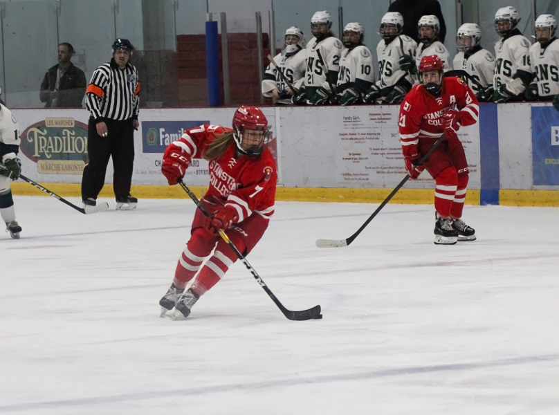 photo of female hockey player skating with puck