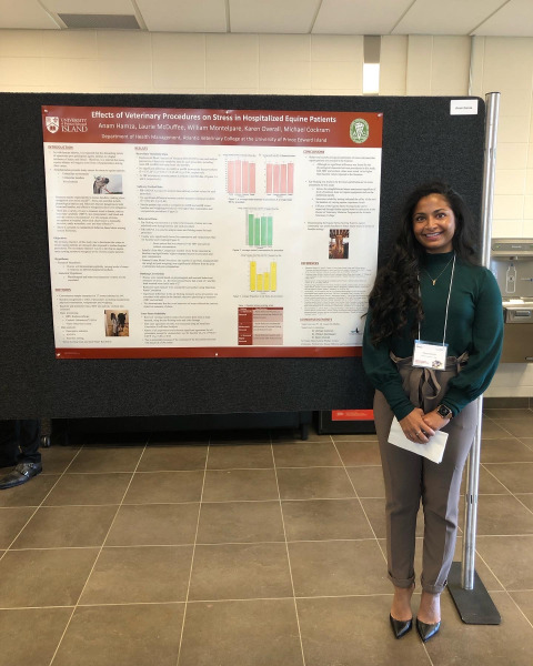 Anam Hamza poses in front of her winning poster. 