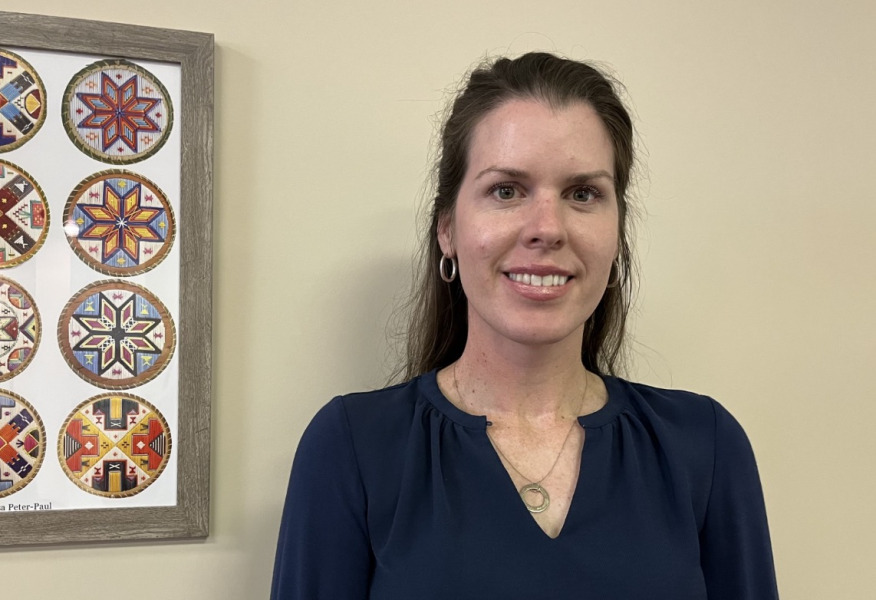 photo of woman standing near a wall hanging