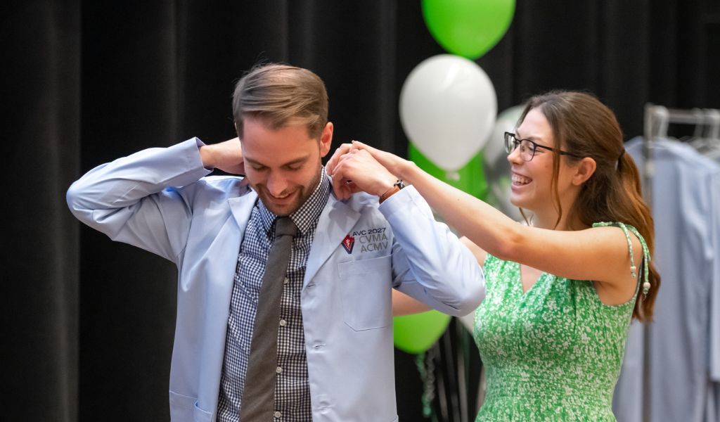 Ryan Subject receives his blue coat from his partner, Brianna Heath