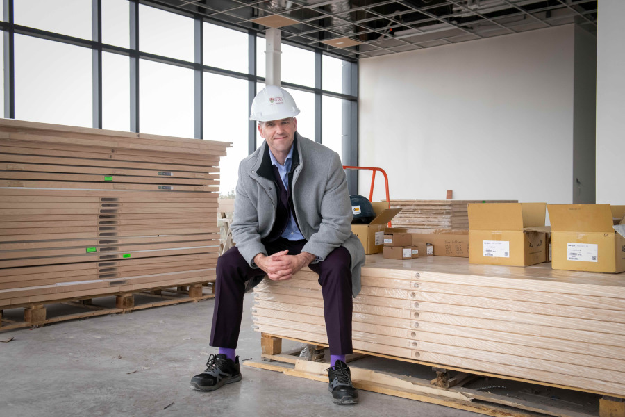 man with hardhat on sitting on materials on construction site