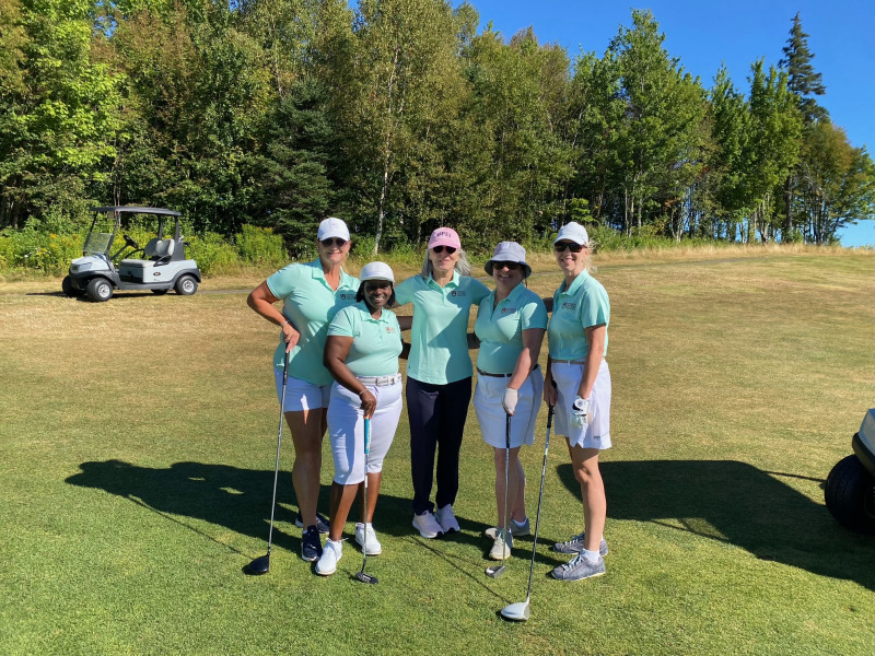 President Wendy Rodgers (centre) joins Office of the President team members (left to right): Heather Howatt, Jane Ngobia, Nicole Phillips, and Pam Trainor photo of five women wearing green shirts, standing on a golf course
