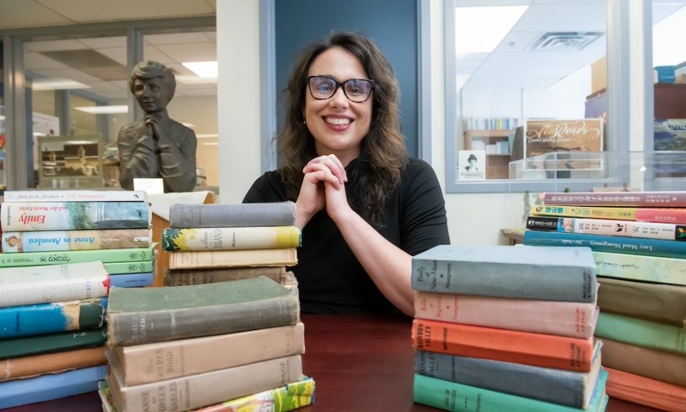 Dr. Kate Scarth, Chair of L.M. Montgomery Studies at UPEI, is surrounded by books by and about PEI author L.M. Montgomery. Dr. Kate Scarth