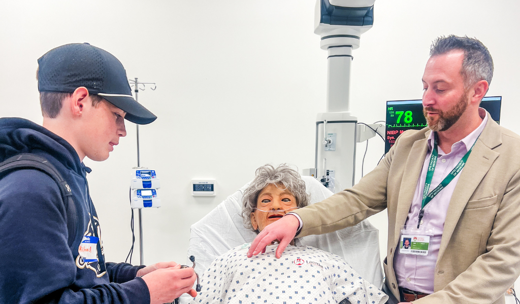 Jeff Clow (right), Director of Academic Affairs, UPEI Faculty of Medicine, shows Michael Gill (left), son of UPEI employees Anthony and Rebecca Gill, how to use a stethoscope on a manikin during a tour of the Clinical Learning and Simulation Centre in the Faculty of Medicine and Interprofessional Health Education Facility.
