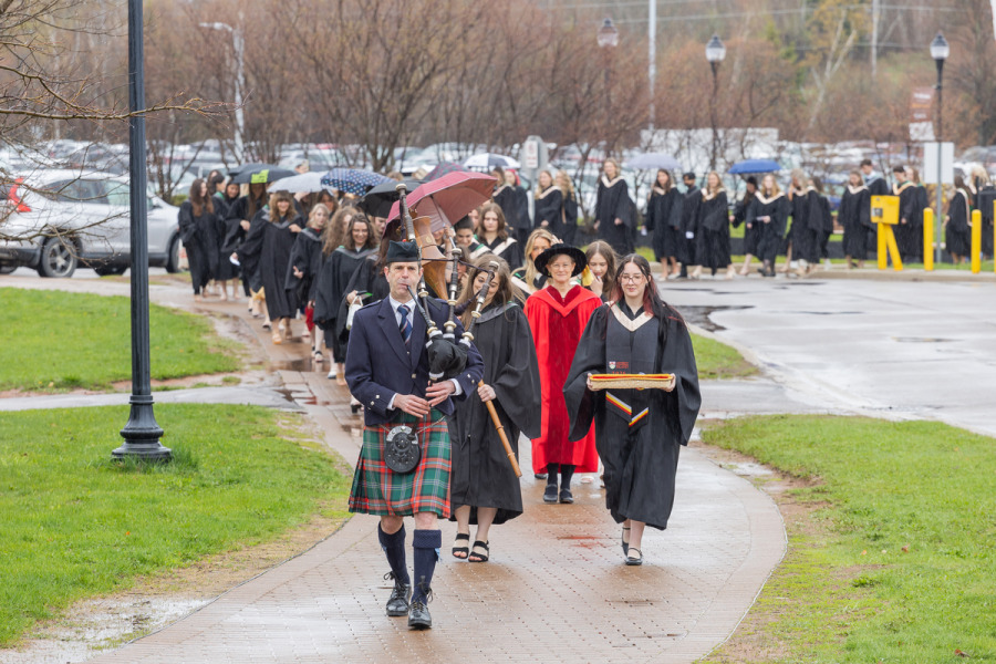 Graduates in the UPEI faculties of Nursing and Veterinary Medicine are led into the Chi-Wan Young Sports Centre for their Convocation ceremony on May 12 by Marshal Dr. Lisa Chilton; Macebearer Dr. Laura Groves, Faculty of Veterinary Medicine; and Eagle Feather Bearer Andrea Gallant, Faculty of Nursing. 