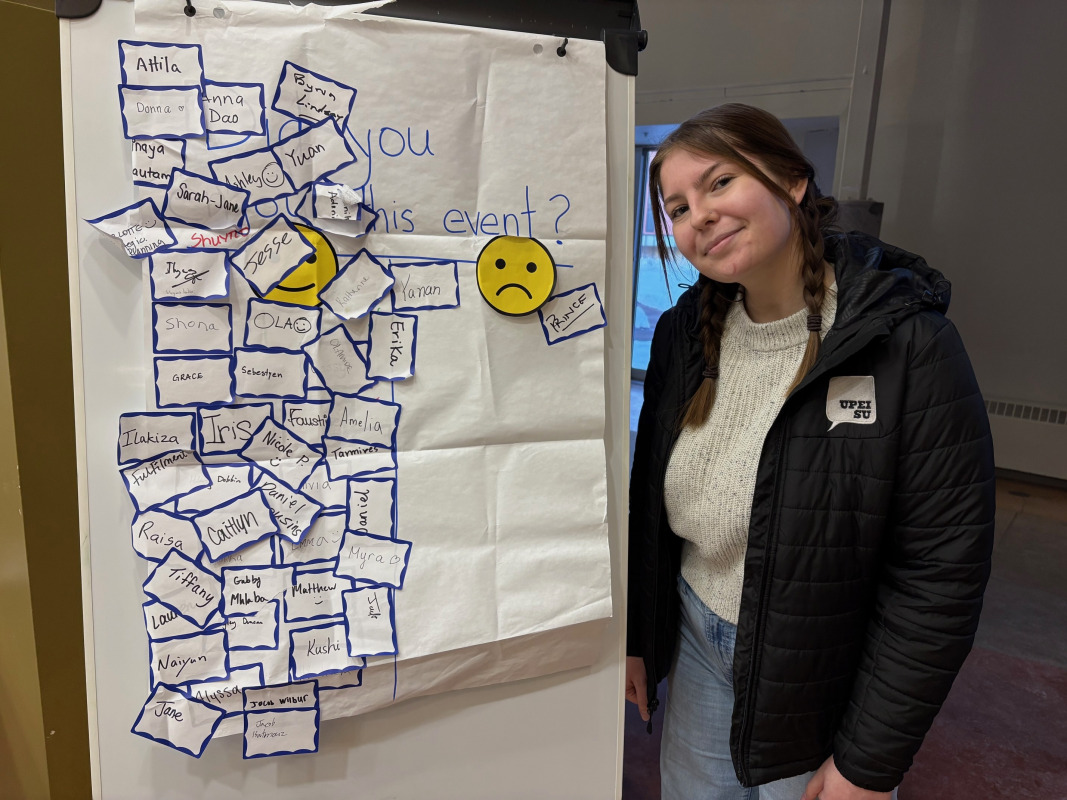 Photo of woman standing next to a flipchart with name tags on it