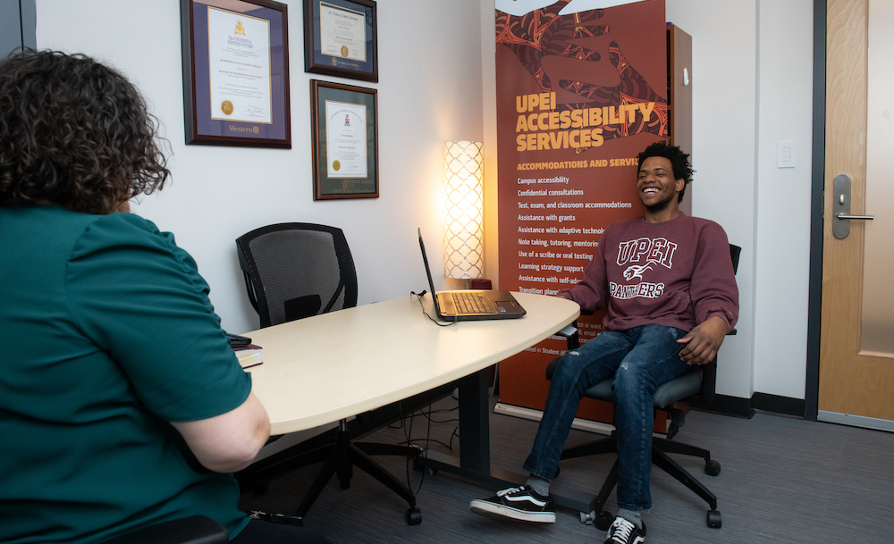 UPEI student Antwaun Rolle speaking with accessibility services coordinator 