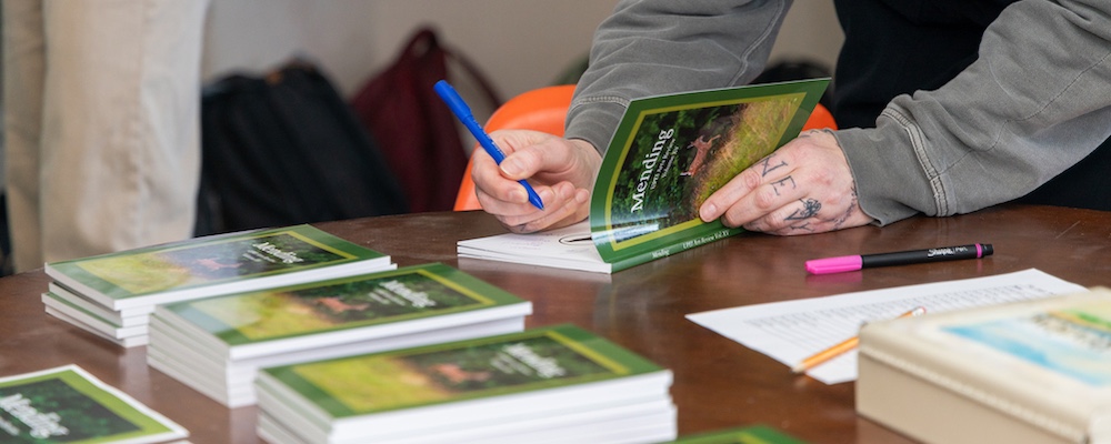 a person signing the inside of a book