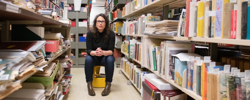 a person sitting in a row of library books