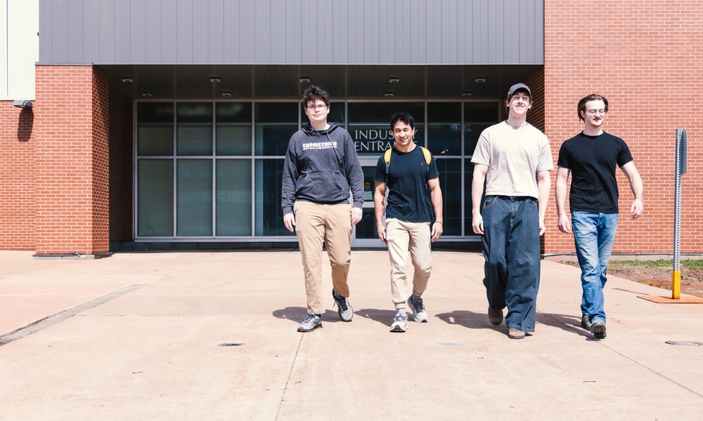 four engineering students outside the Faculty of Sustainable Design Engineering building