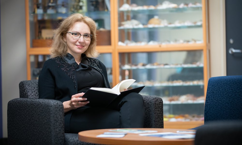 Dr. Nino Antadze reading a book in the AVC Learning Commons 