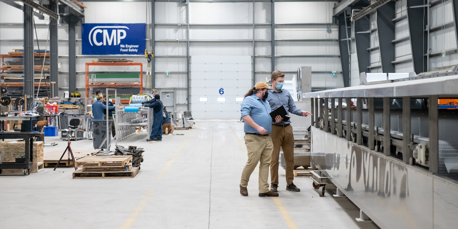 upei engineering graduate and professional engineer peter doiron and a colleague inspecting a food processing equipment line