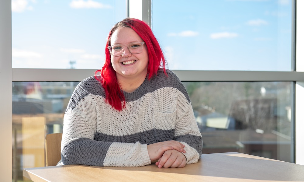 a UPEI student in the Performing Arts Centre and Residence lounge