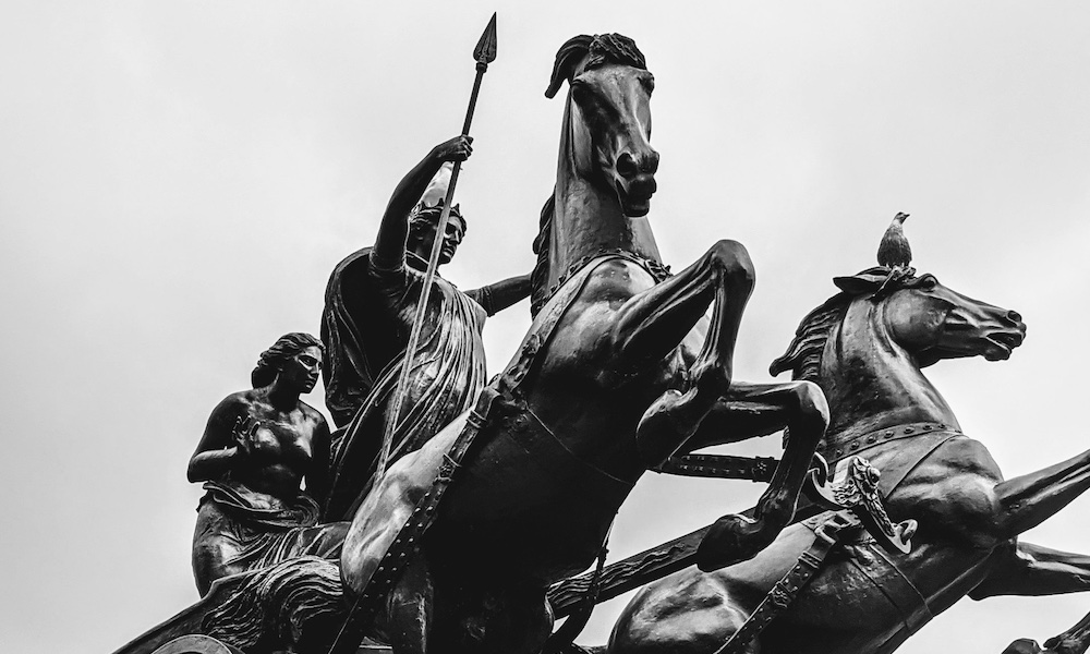 statue of a man riding a chariot pulled by two horses