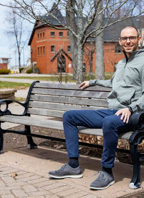 Peter Blanchard sitting on a bench in UPEI's quad