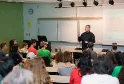 A man teaches at the front of a classroom