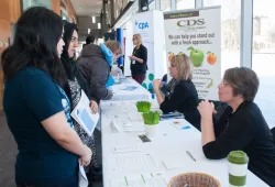 Two female students speak with a prospective employer