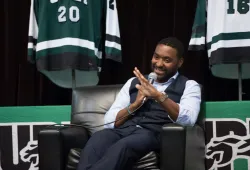 A man laughs as he speaks into a microphone