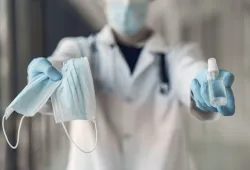 image of someone holding masks, sanitizer