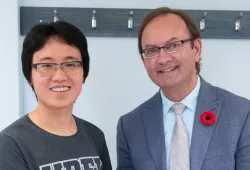 A smiling young woman with short dark hair and a smiling older man