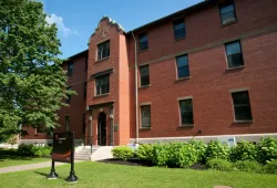 A symmetrical three-story building of brick and stone with a central entrance