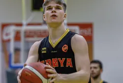 A male basketball player eyes the net looking to take a shot