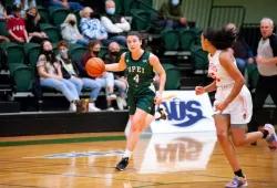 Photo of female basketball player dribbling ball