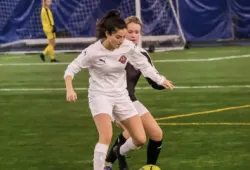 photo of woman dribbling soccer ball with opponent nearby