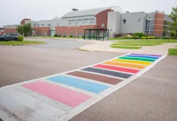 photo of crosswalk in front of Student Centre painted in Progress Pride colours