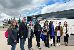 group of people standing in front of a bus