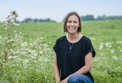 Casey Whitehouse smiles in a field on PEI