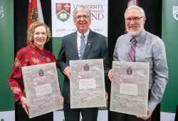 photo of three people holding presentation plaques