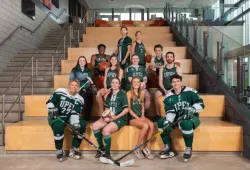 photo of athletes wearing their uniforms sitting on a staircase