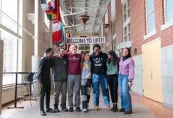 photo of 7 students standing together in large concourse