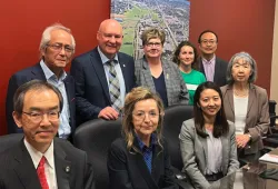 photo of a group of people sitting and standing behind a table