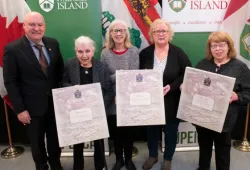 photo of of five people standing holding three plaques