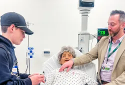 Jeff Clow (right), Director of Academic Affairs, UPEI Faculty of Medicine, shows Michael Gill (left), son of UPEI employees Anthony and Rebecca Gill, how to use a stethoscope on a manikin during a tour of the Clinical Learning and Simulation Centre in the Faculty of Medicine and Interprofessional Health Education Facility.