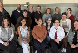 Photo of large group of people, some standing and others sitting