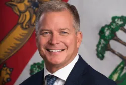 Photo of man smiling with PEI flag in background