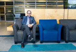 Photo of man sitting in a chair in a common area