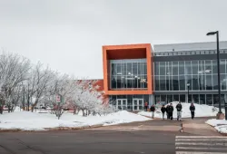 photo of students walking in front of modern campus building