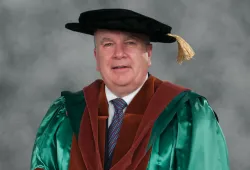 Photo of man wearing academic regalia and hat