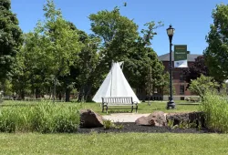 photo of tipi and the campus quad with a welcome banner in the foreground