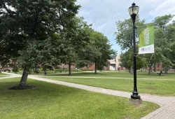 photo of campus quadrangle with a lamp post and banner in foreground