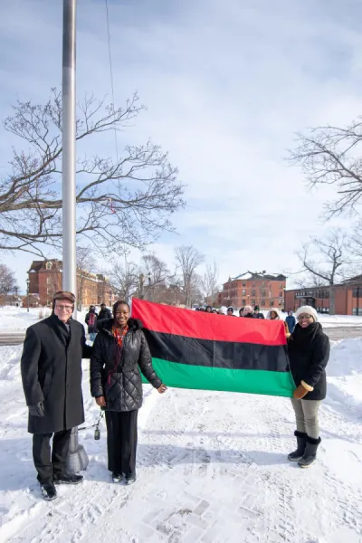 three individuals with the Pan-African flag