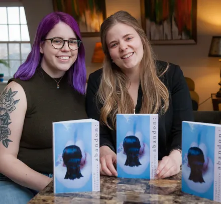 students sit at a table with the UPEI Arts Review publication