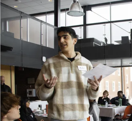 a student explaining a presentation to two people