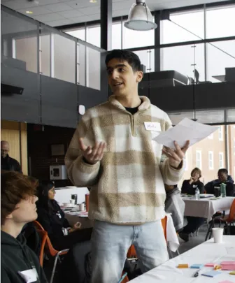 a student explaining a presentation to two people
